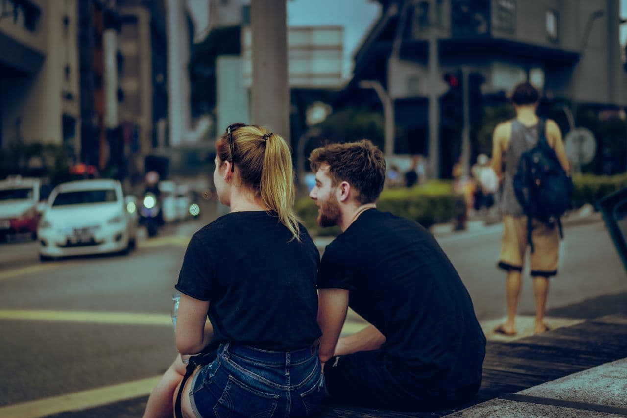 woman-and-man-sitting-on-bench-and-talking